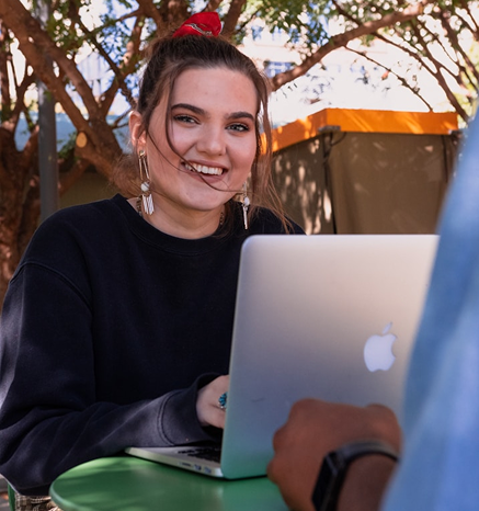 Students working together with a laptop outdoors